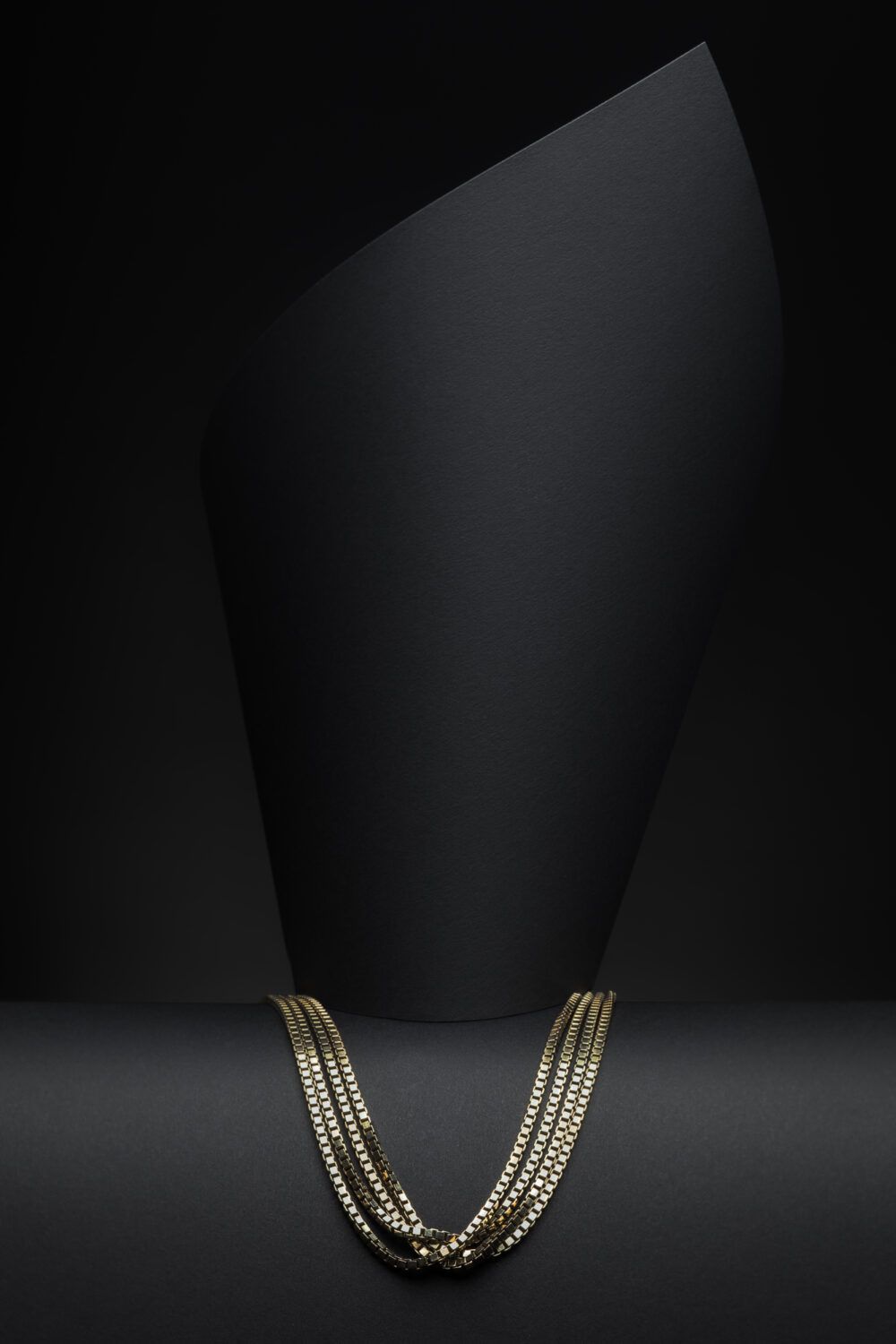 Ein goldenes Halsband auf schwarzem Hintergrund im Photostudio Luzern für Werbefotografie und Produktfotografie